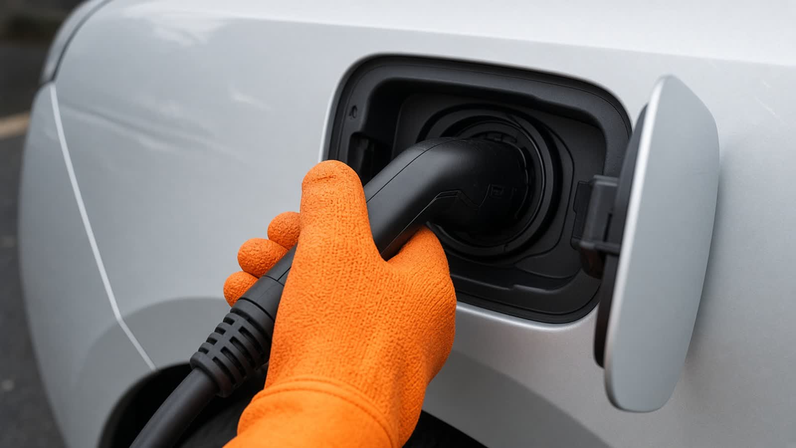 Insulating gloves at an electric-vehicle charge port, the B0L line VoltWork prints